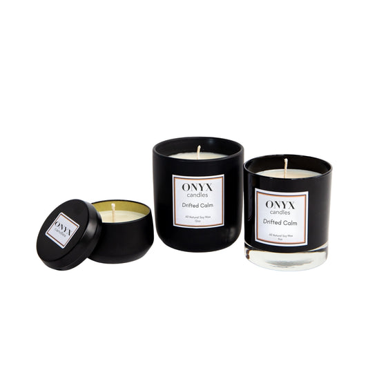 Pictured are three size variants of Onyx candles in the scent Drifted Calm