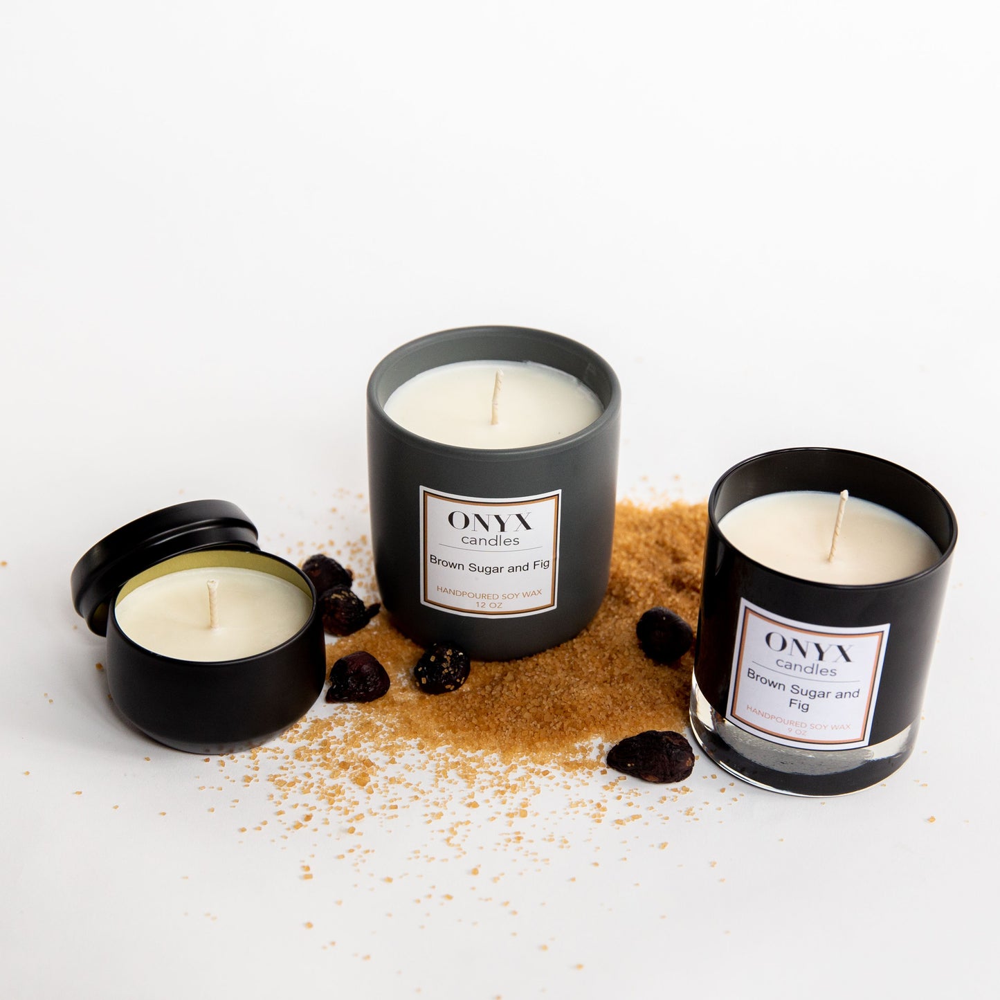 Pictured are three size varieties of Onyx candles in the scent of Brown Sugar and Fig