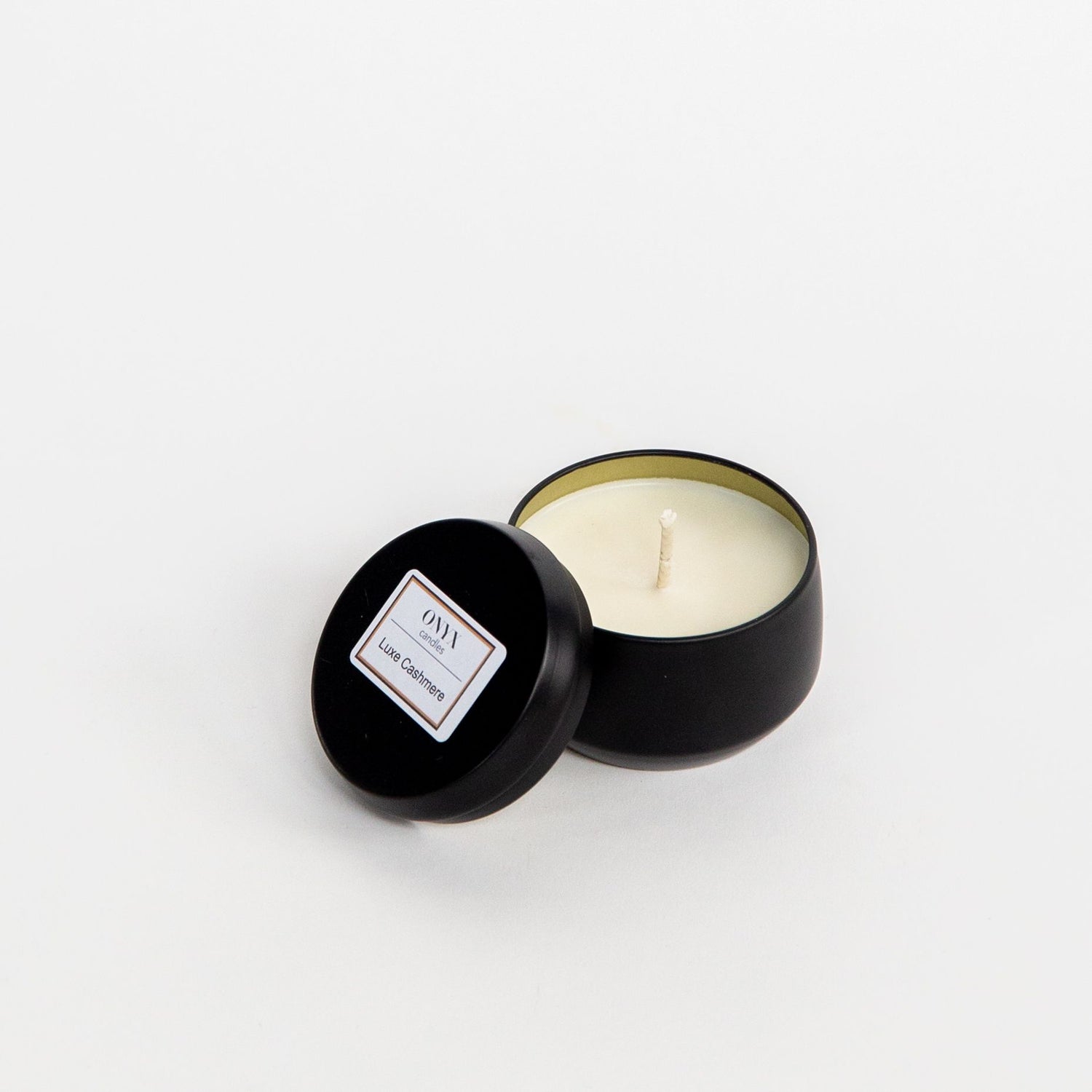 Pictured is the Luxe Cashmere scented candle in a 4 oz matte black tin