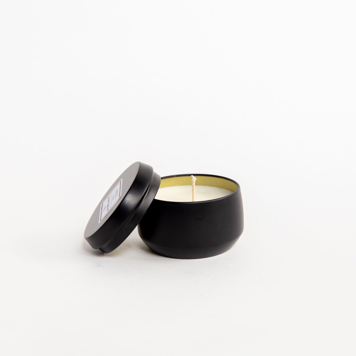 Pictured is the 4 oz matte black tin candle option in the scent of Cedar and Balsam