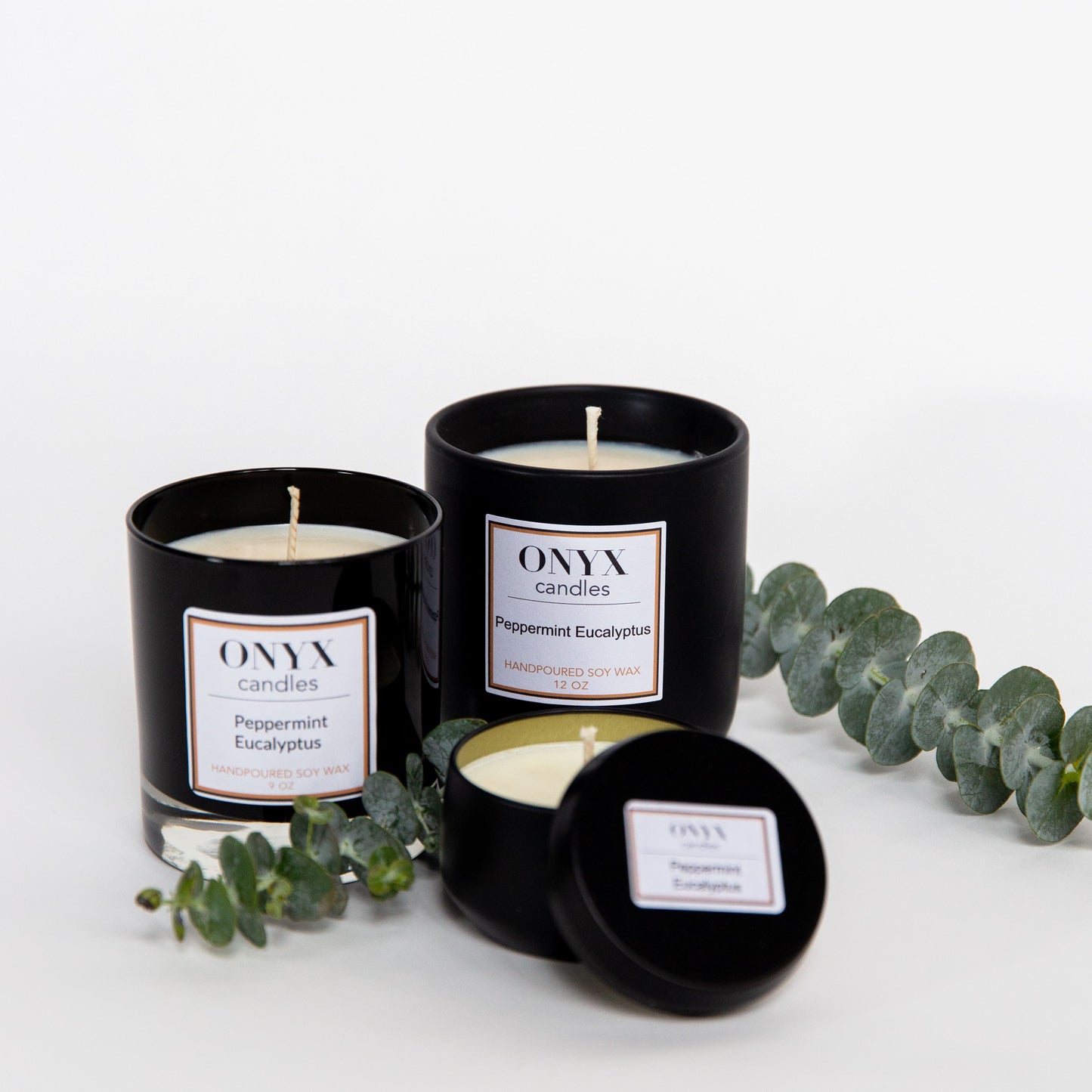 Peppermint Eucalyptus candle variants, from left to right are the 9oz black glass jar option, the 12oz matte black ceramic option, and  the 4oz matte black tin