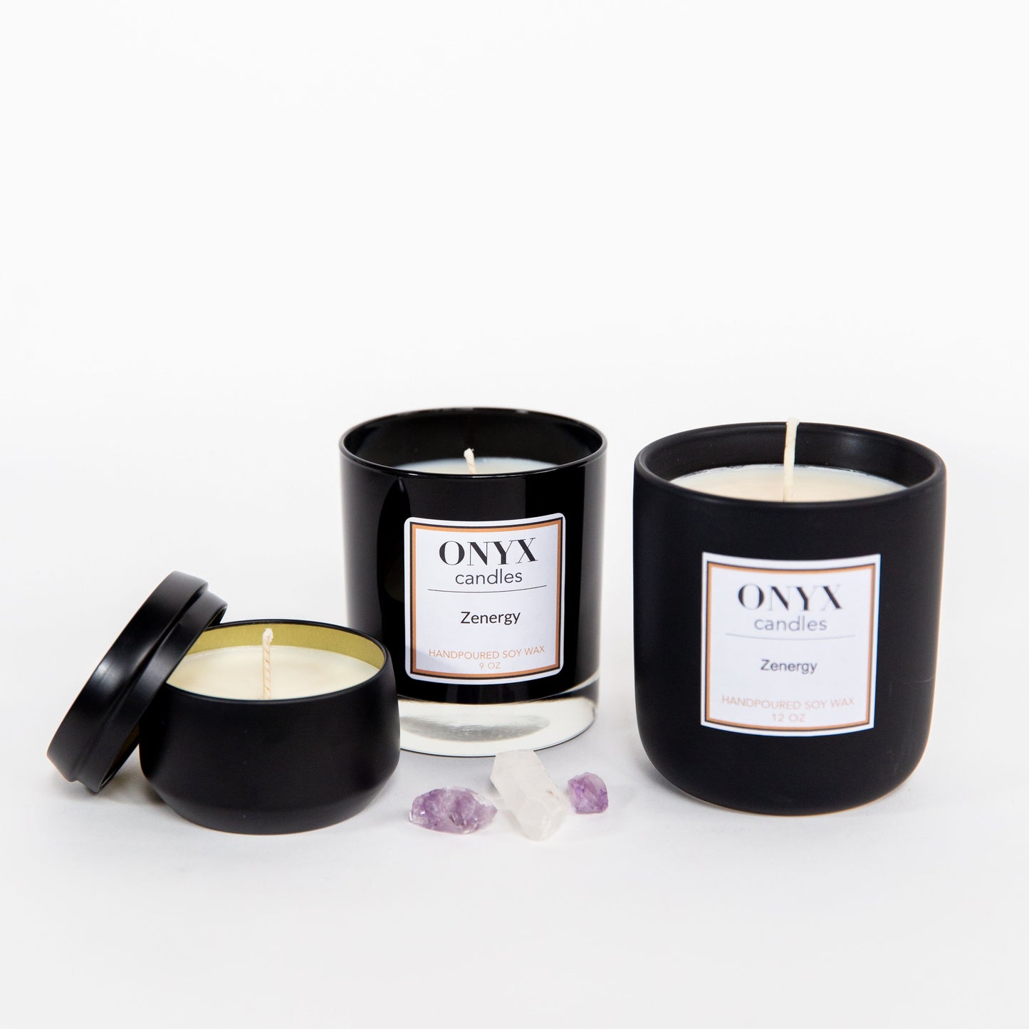 Zenergy candle collection in three size varietals. Shown left to right is the 4oz matte black tin, the 9oz black glass jar, and the 12oz matte black ceramic jar
